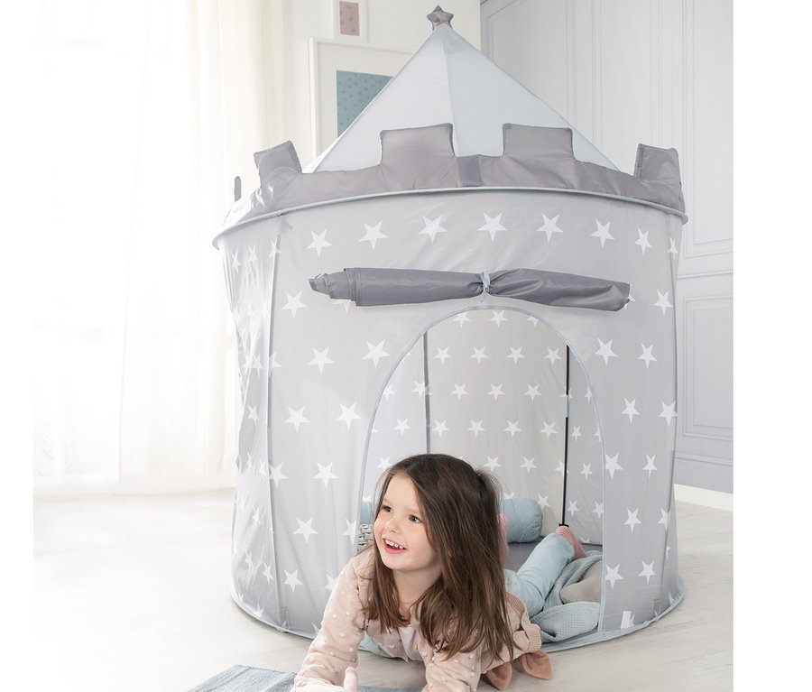 Mädchen liegt vor grauem roba Spielzelt »Ritterburg« mit weißen Sternen auf dem Boden.