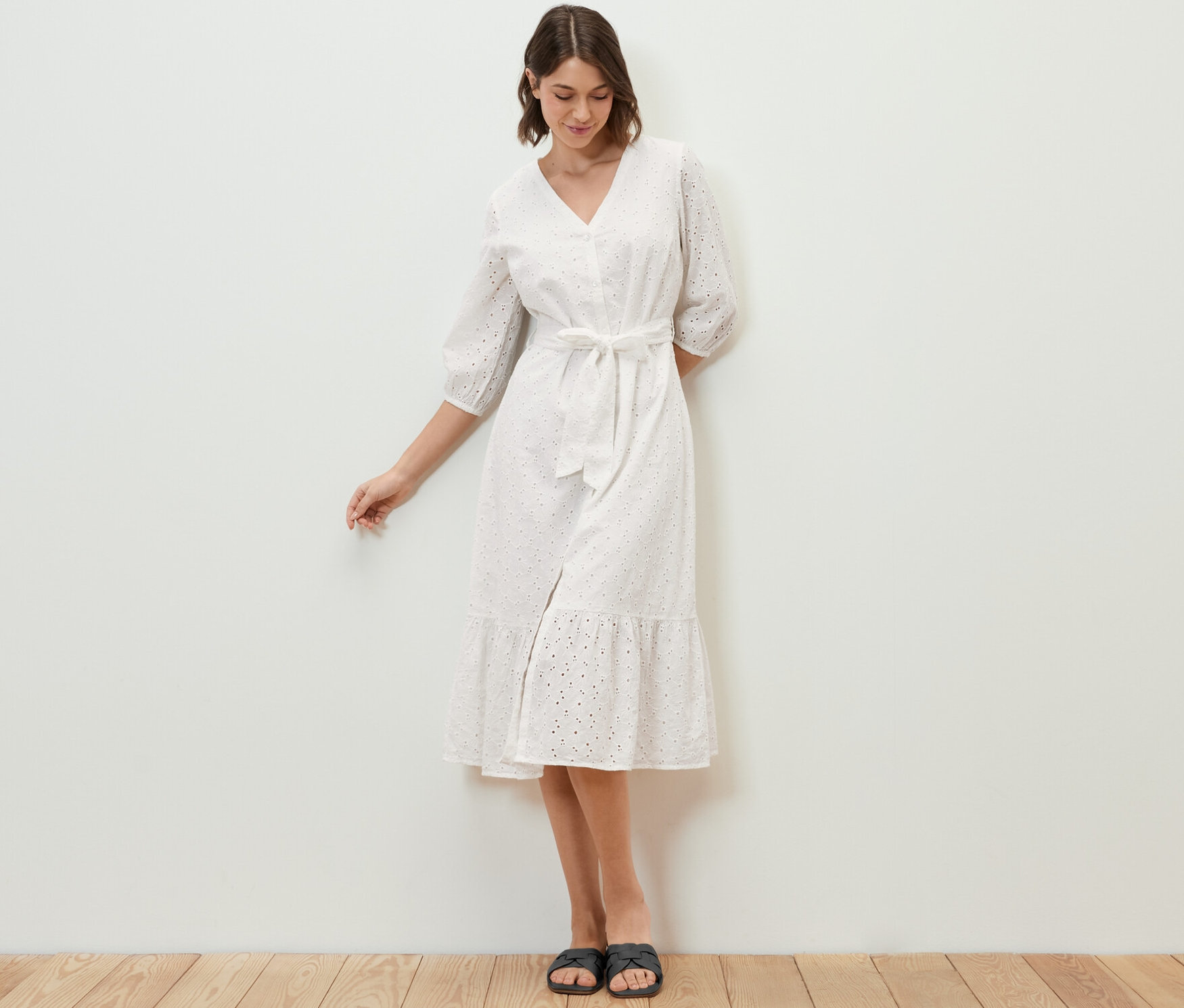 Frau steht und trägt ein Blusenkleid mit Lochstickerei.