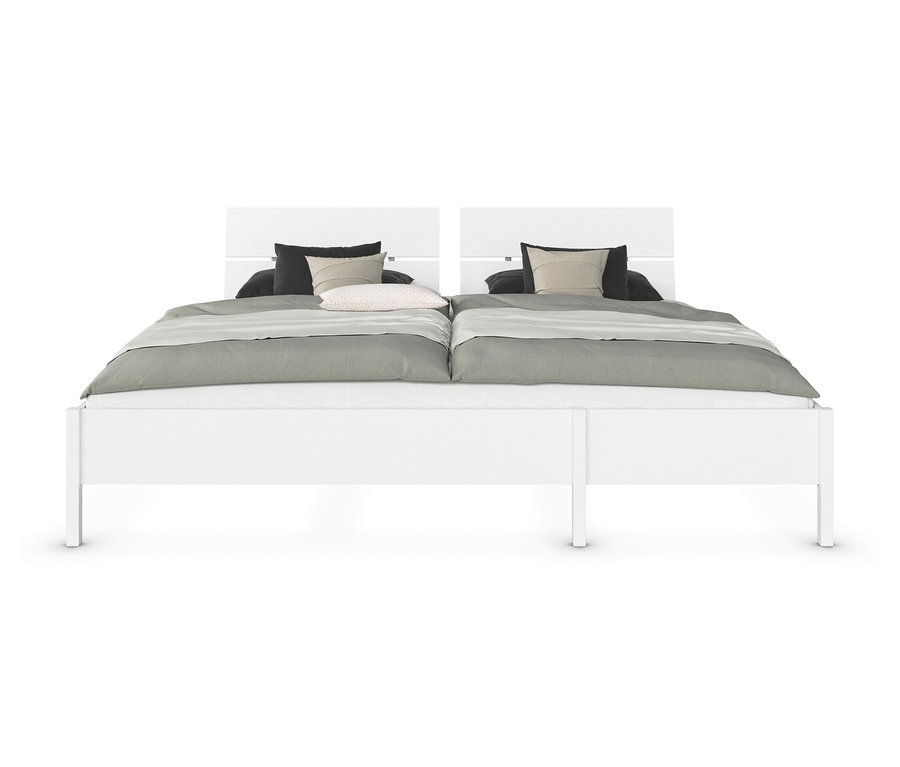 Doppelbett mit weißem Rahmen, grauer Bettwäsche und Kissen.