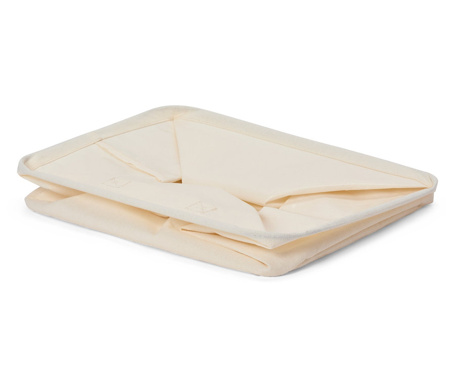 Gefaltete, cremefarbene Stoffaufbewahrungsbox.