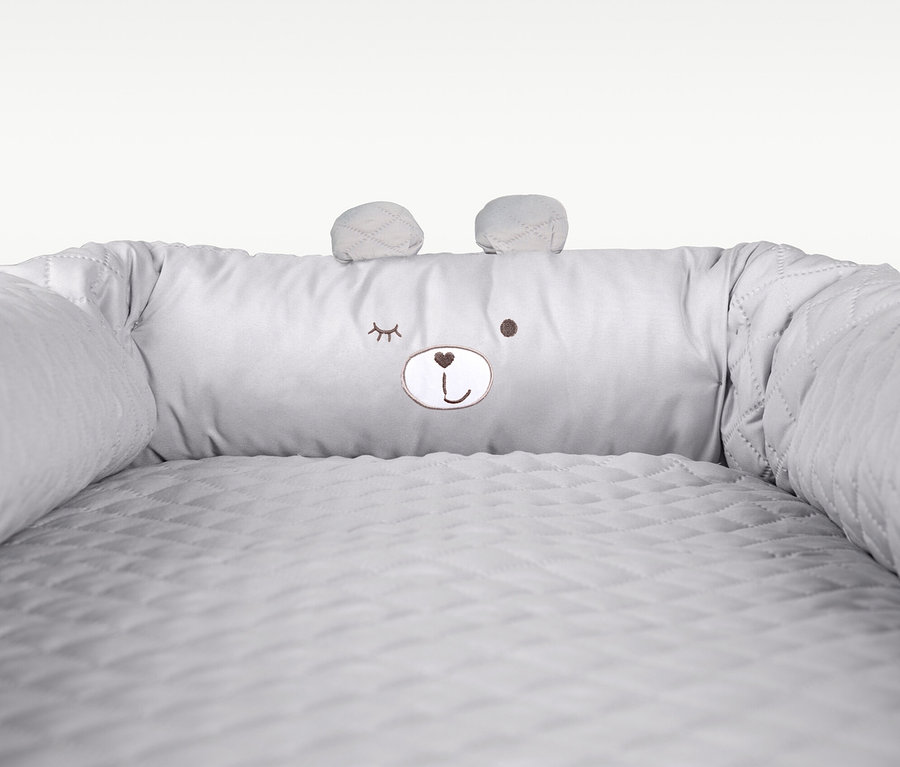 Detailansicht einer grauen Babylounge von Roba mit aufgesticktem Bärengesicht.