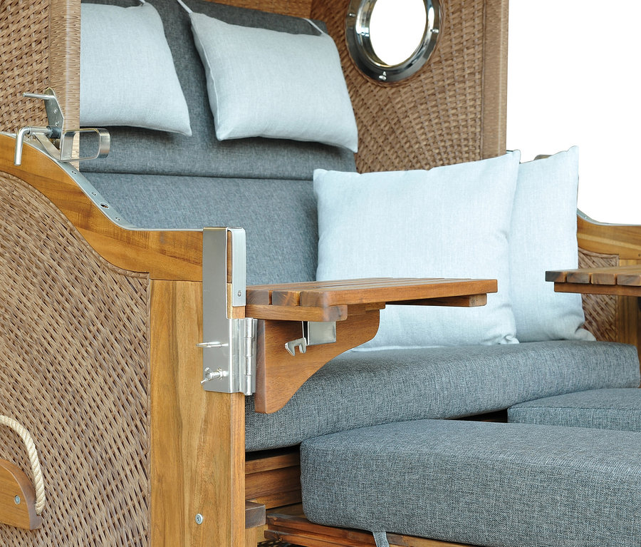 Detailansicht eines DeVries Strandkorbs, Akazie, XL mit grauem Polster und weißen Kissen.