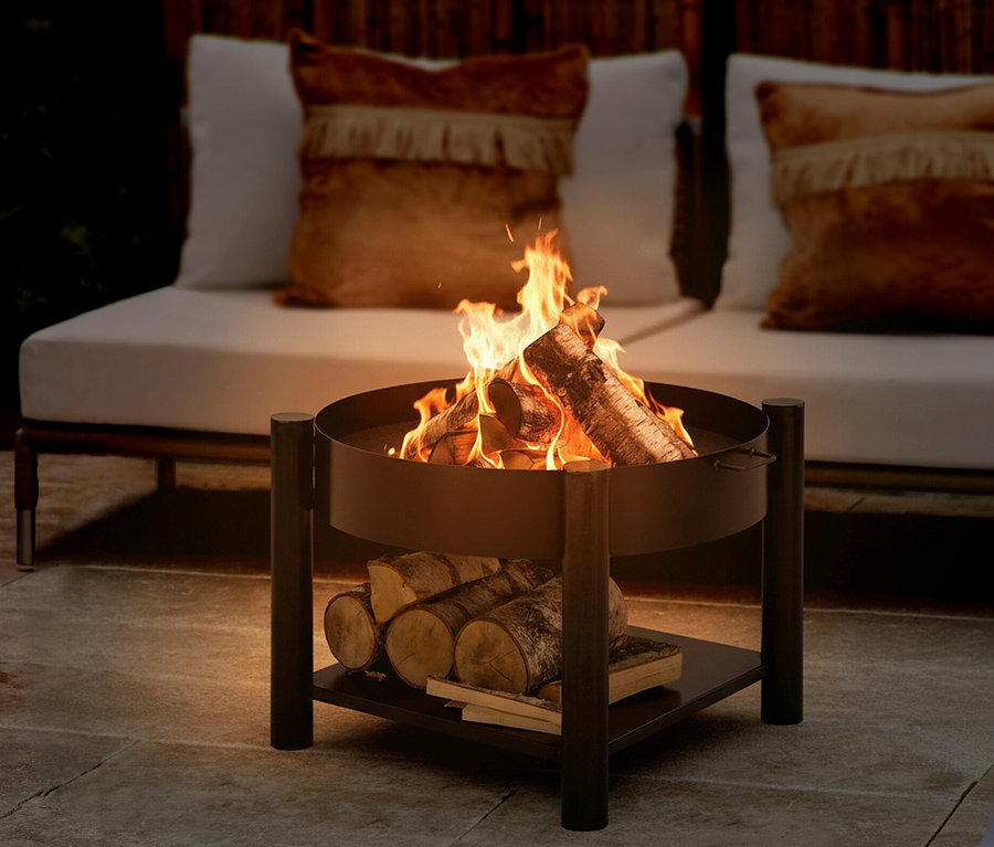 Flammen lodern in der Buschbeck Feuerschale »Zahara« (Ø 60 cm). Holzscheite liegen auf der Ablage unterhalb der Schale.