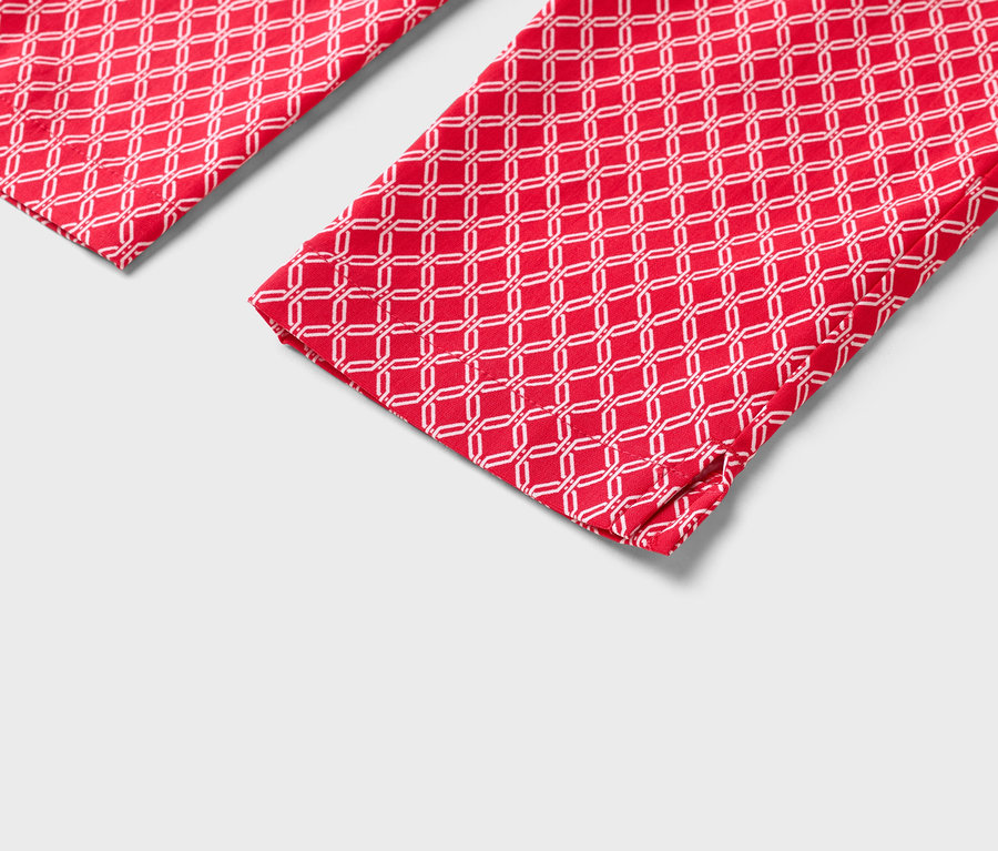 Detailansicht von zwei roten Hosenbeinen mit weißem geometrischen Muster.