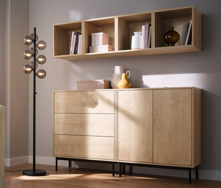 Wohnzimmer mit Sofa, Stehleuchte »Glaskugeln« und Regalmodulen »Flemming« in Eichendekor.