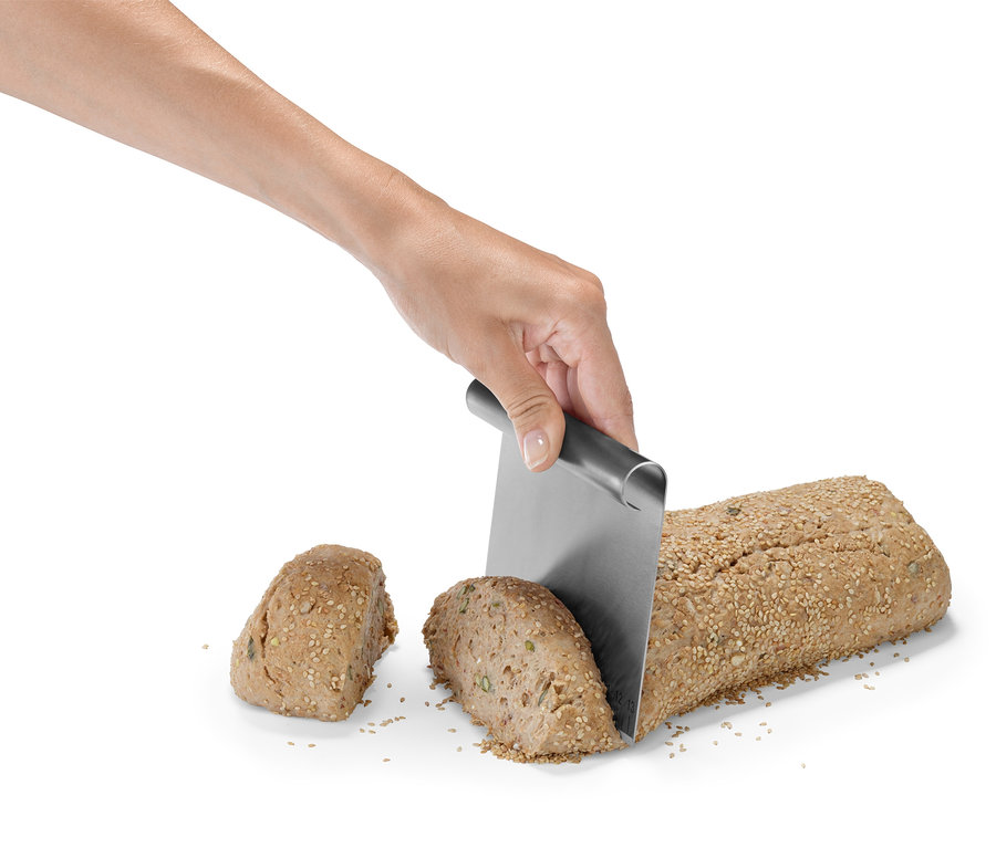 Eine Hand schneidet Brot mit einem Profi-Backhelfer-Set.