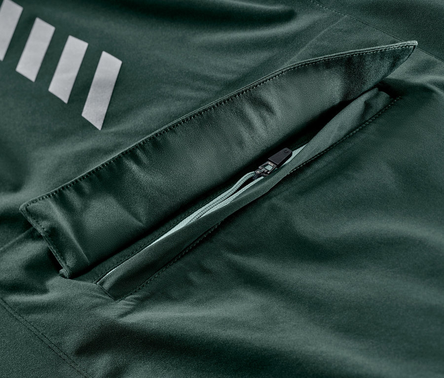 Detail einer Rad-Regenjacke mit silbernen Streifen und Reißverschlusstasche.