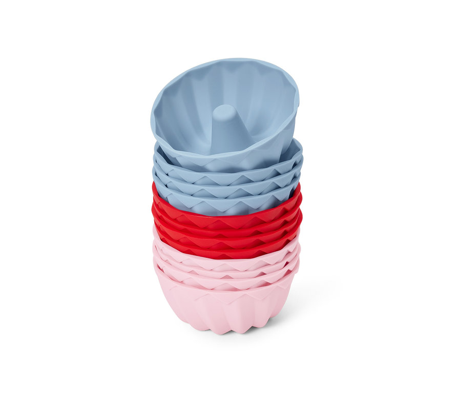 Stapel aus 12 Mini-Gugelhupfformen in Rosa, Rot und Blau.