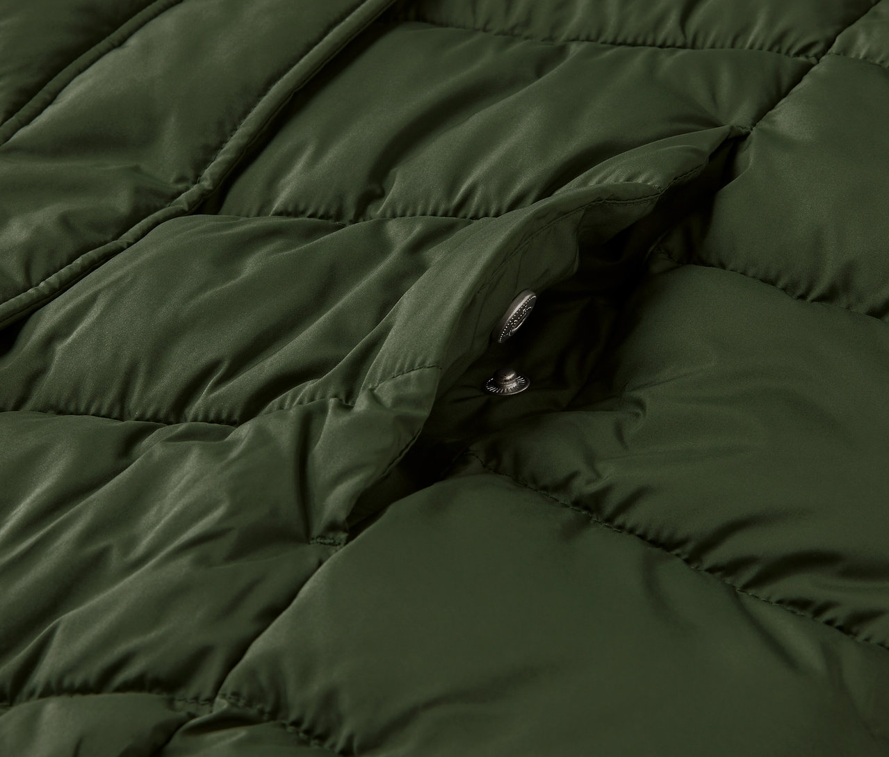 Detailansicht eines dunkelgrünen Steppmantels mit Kapuze.