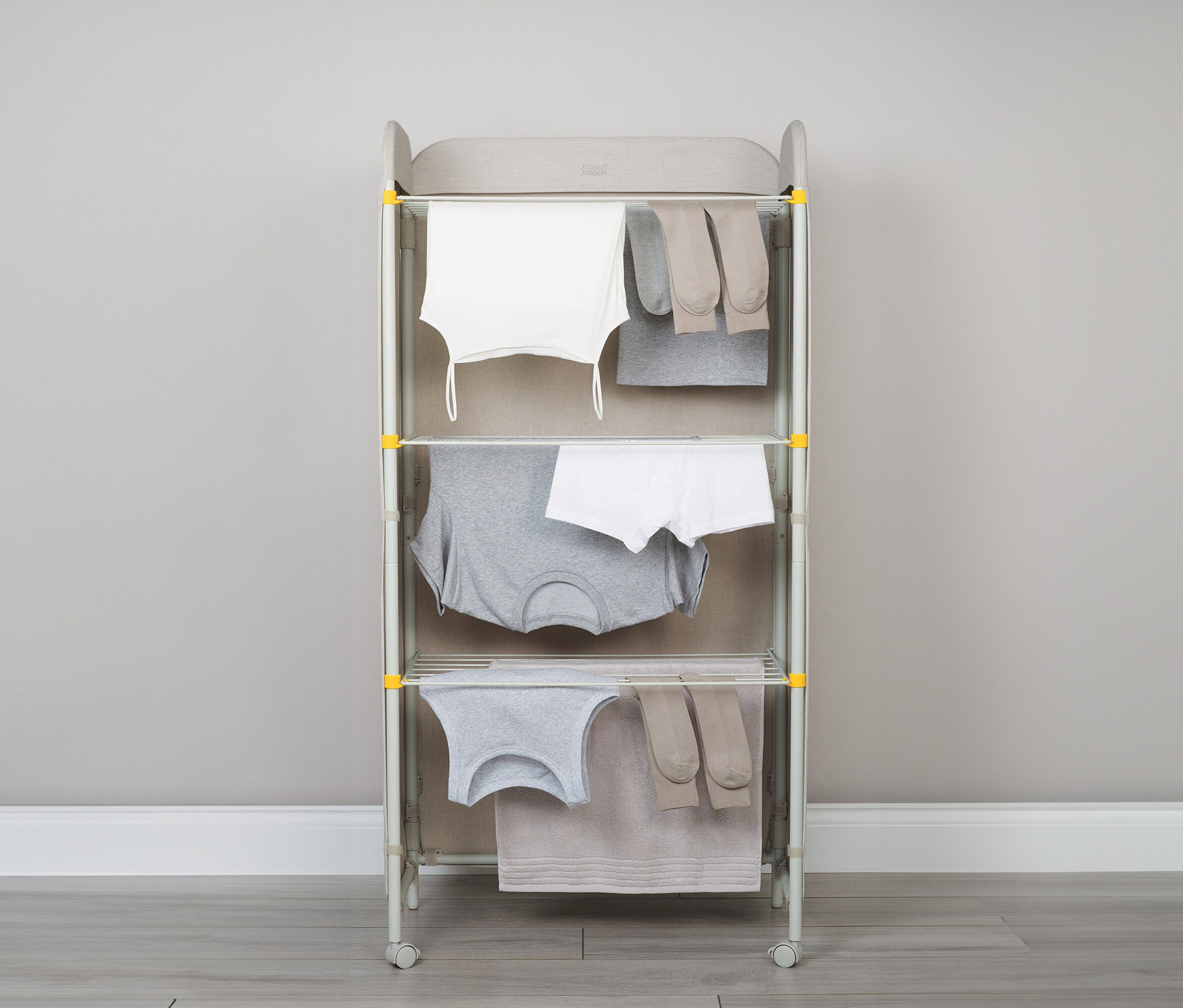 Ein Wäscheständer mit drei Ebenen, voll mit Kleidung.