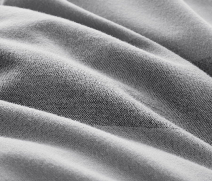 Nahaufnahme eines grauen Stoffes mit Textur und Falten.