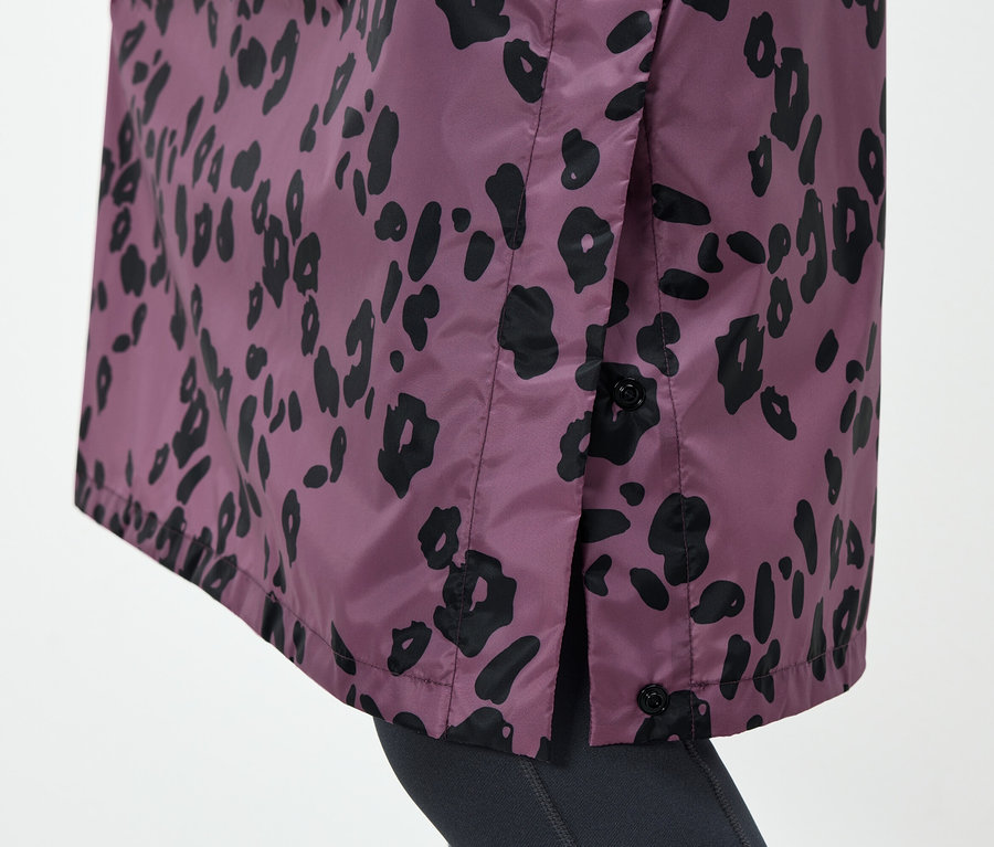 Detail einer lila Jacke mit schwarzem Tiermuster und Knöpfen an der Seite.