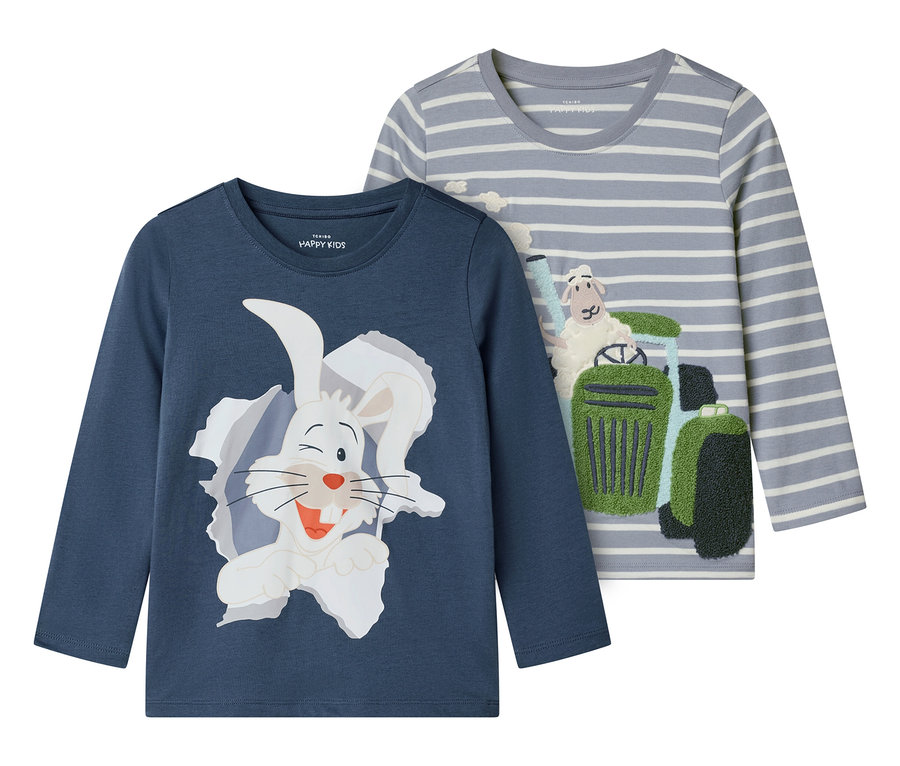 Zwei langärmelige Kinder-Shirts liegen nebeneinander. Das eine ist blau mit einem weißen Hasen, das andere ist grau gestreift mit einem Schaf auf einem Traktor.
