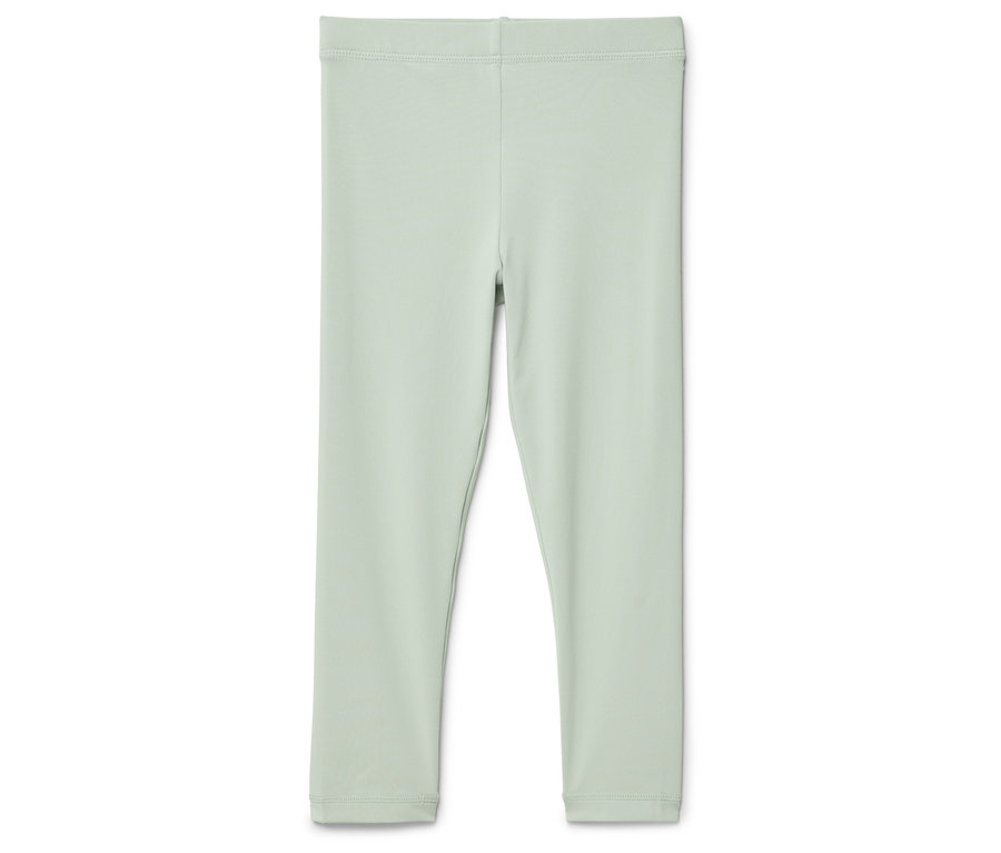 Eine hellgrüne Leggings liegt auf einem weißen Hintergrund.