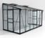 Ein schwarzes Vitavia Anlehngewächshaus mit 7,8 m2, inklusive Fundamentrahmen, lehnt an einer weißen Wand.