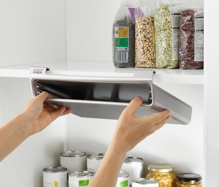 Hände nehmen das Joseph Joseph Schneidebrett-Set »Folio Slim« aus dem Schrank.