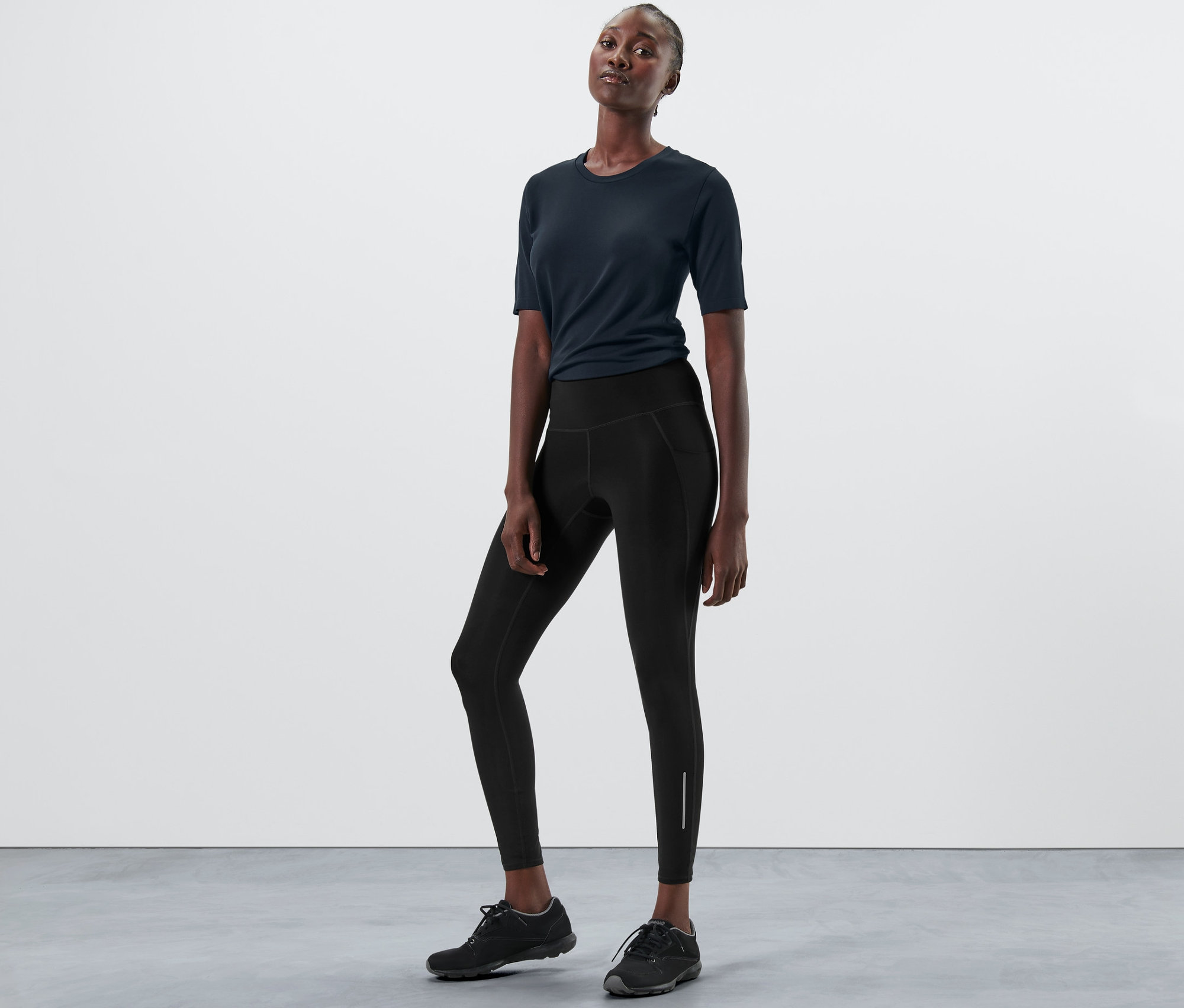 Frau posiert in schwarzen Sporttights.