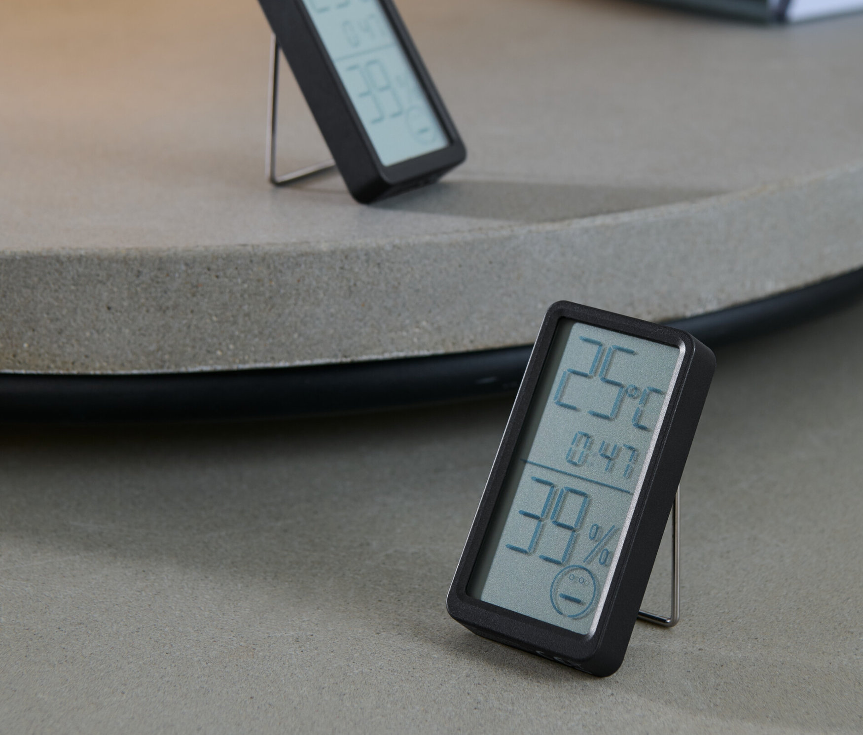 Zwei schwarze digitale Raumthermometer auf einem Tisch.