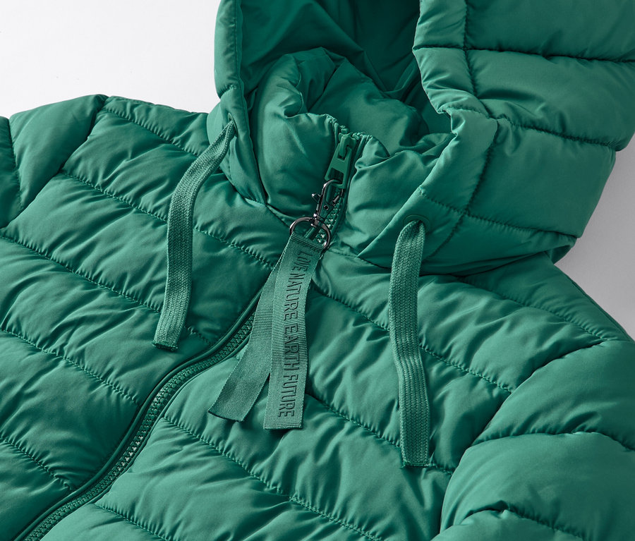 Detailaufnahme eines grünen Steppmantels mit Kapuze.