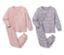 Zwei Kinder-Pyjamas, rosa mit Prinzessinnen-Motiv und lila mit Schwanen-Motiv.