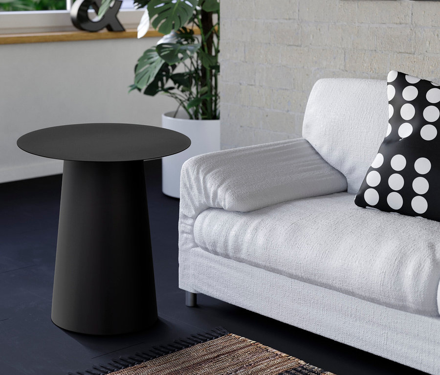 Schwarzer Beistelltisch neben einem weißen Sofa mit einem schwarz-weiß gepunkteten Kissen.