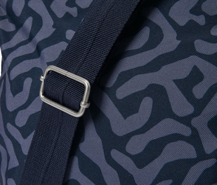 Nahaufnahme einer Tasche mit blauem Muster und einem silbernen Schnallenverschluss am Trageriemen.