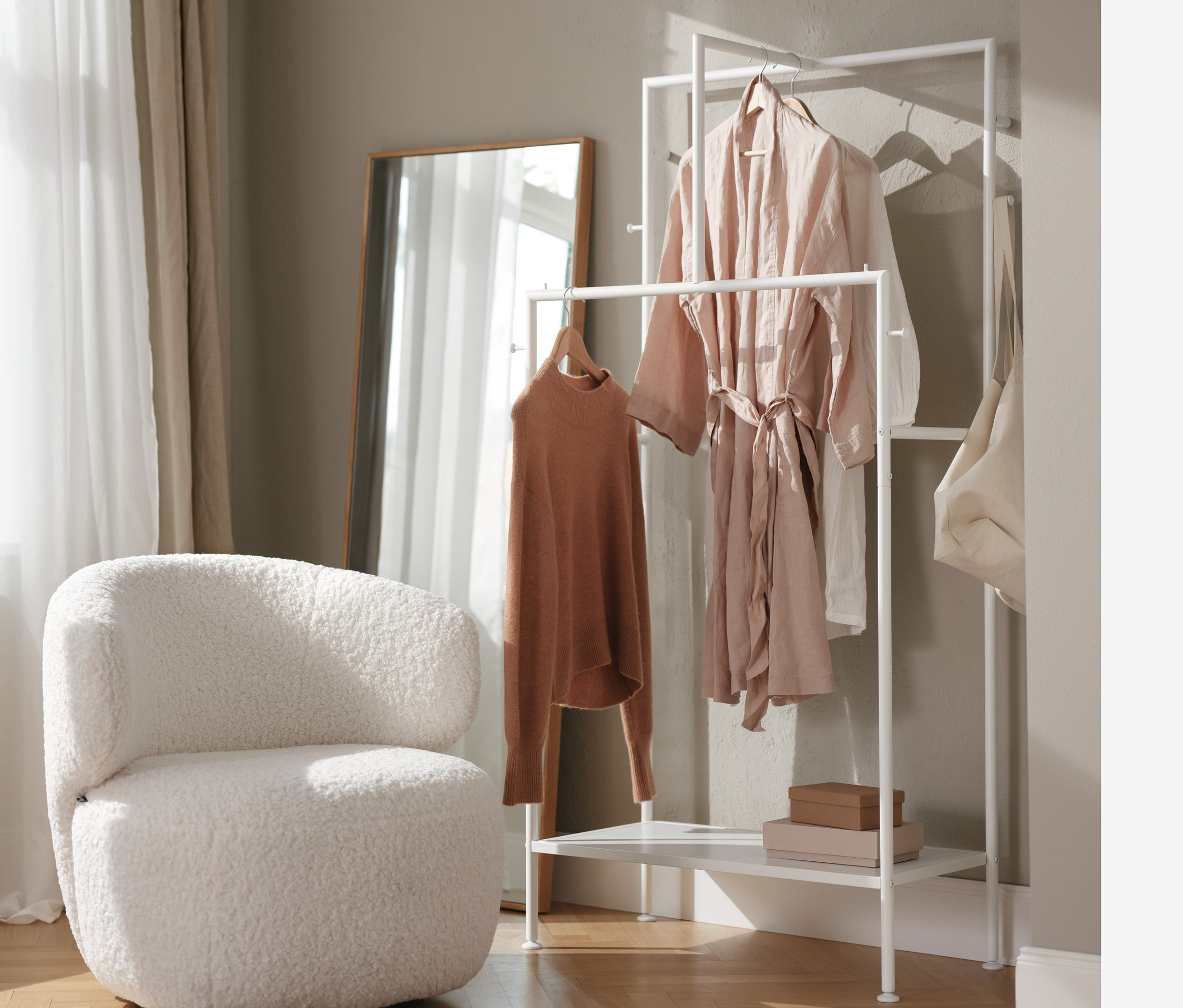 Innenraum mit Drehsessel, Garderobenständer und Wandspiegel.