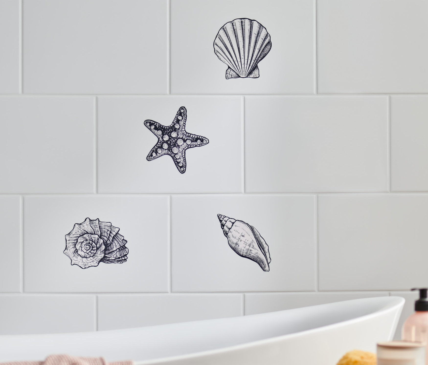 Maritime Fliesenaufkleber mit Muscheln und Seesternen auf weißen Fliesen.