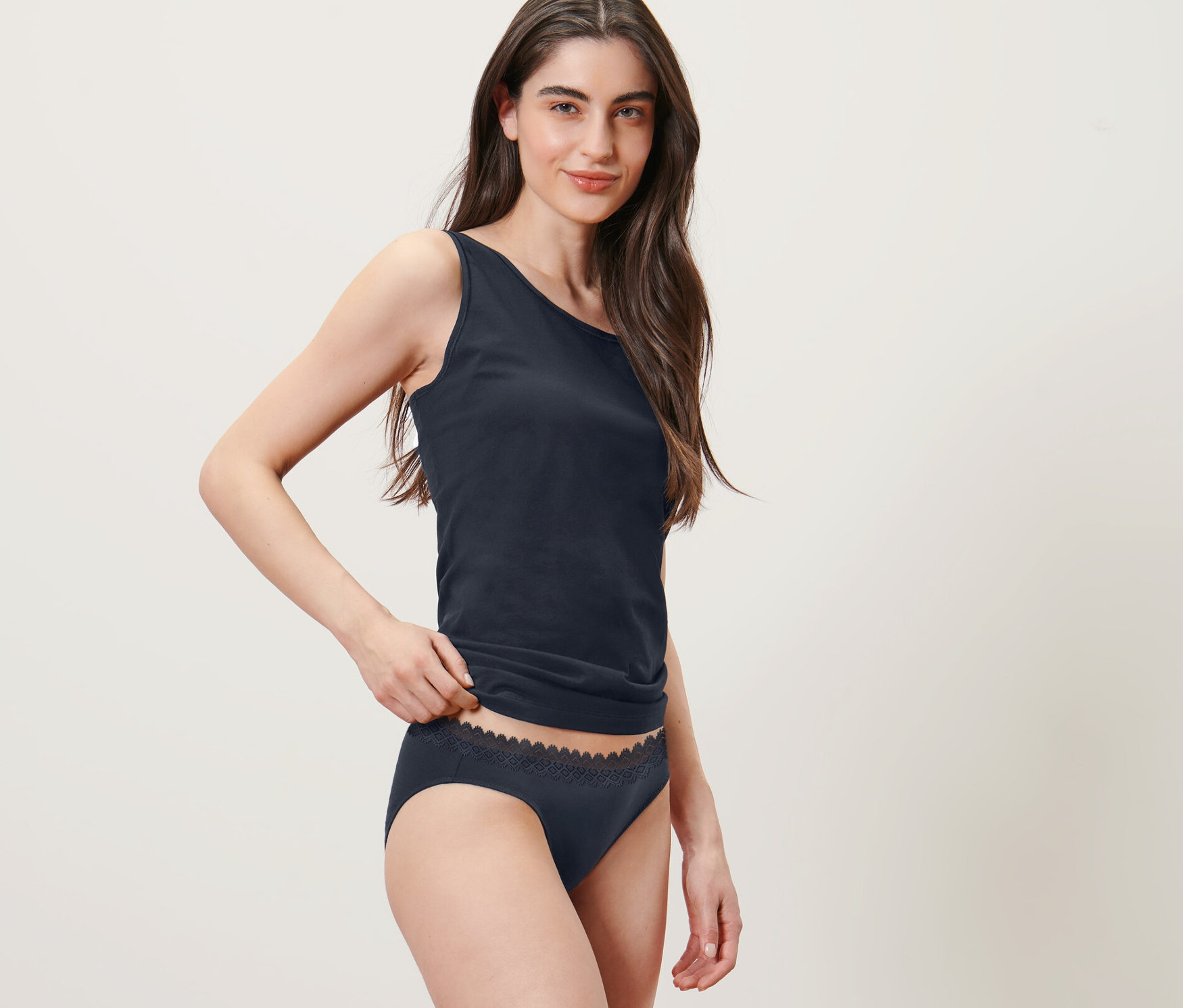 Frau posiert in Tanktop und 2 Slips, dunkelblau.