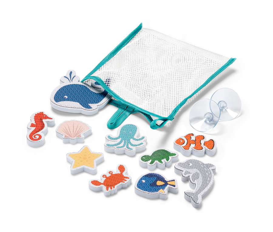 Zehn Badewannenspielfiguren »Meerestiere« liegen neben einem weißen Netzbeutel mit türkisfarbenem Rand und zwei transparenten Saugnäpfen.