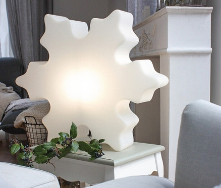 Eine 60 cm große 8 seasons design LED-Schneeflocke steht auf einem Tisch im Wohnzimmer.