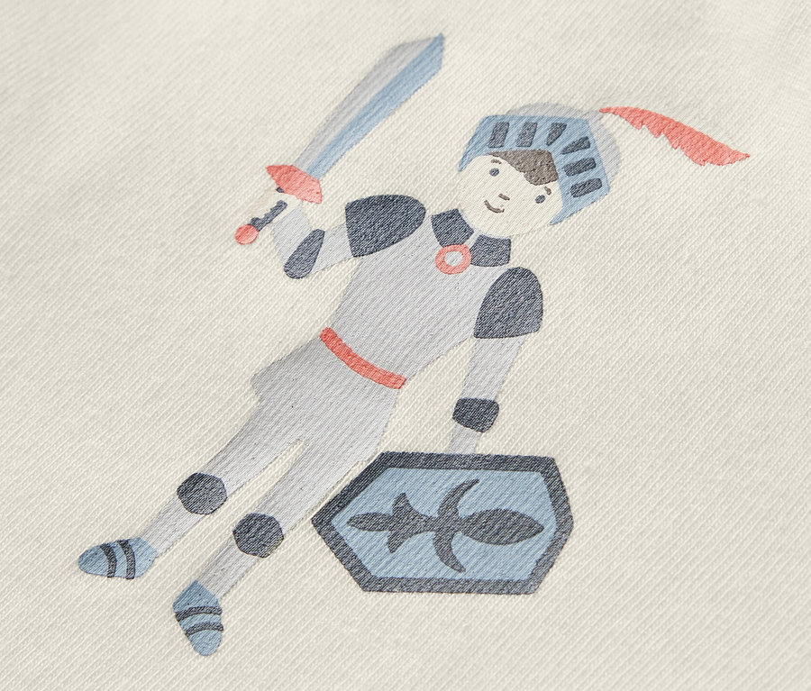 Auf einem Babybody ist eine Ritter-Abbildung mit Schwert und Schild.