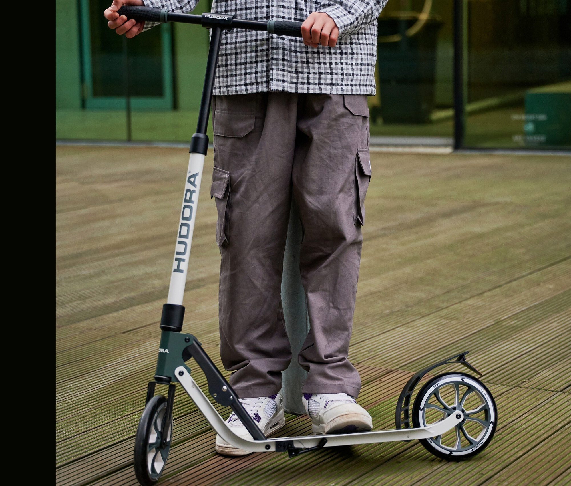 Person steht auf einem grau-weißen HUDORA BigWheel® 205 Scooter.