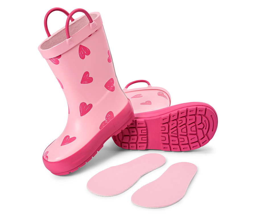Ein Paar rosa Gummistiefel mit Herzmuster und rosa Einlegesohlen liegen auf einem weißen Hintergrund.