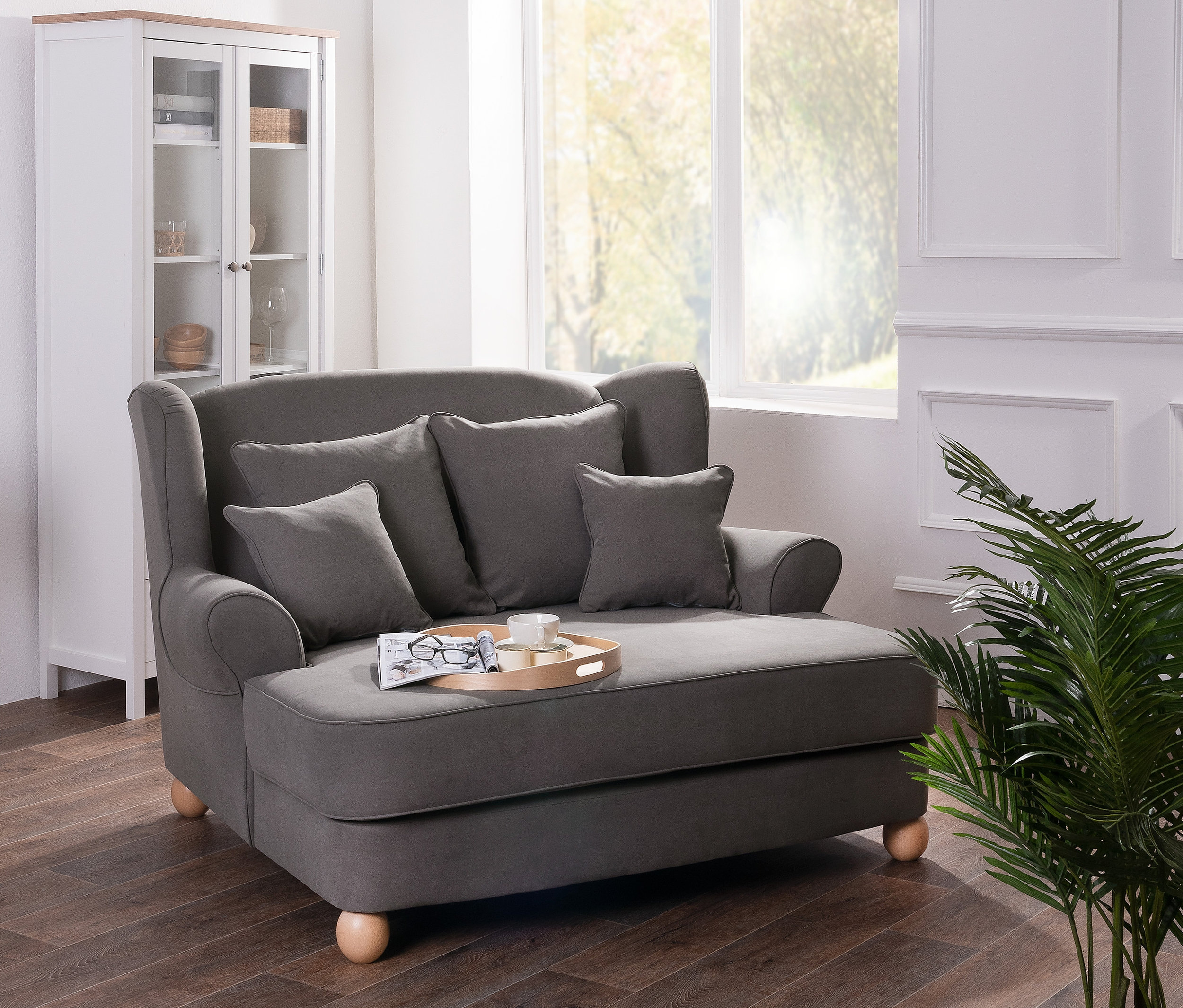 Grauer Max Winzer® XXL-Ohrensessel »Harvard« mit Kissen steht im Wohnzimmer.