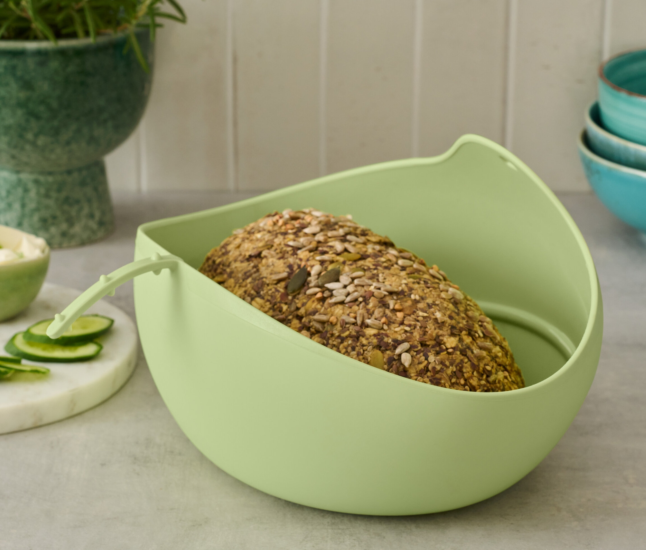 Brot liegt in hellgrüner Brotbackschale.