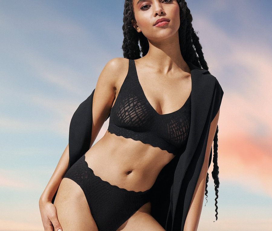 Frau posiert in schwarzem sloggi ZERO Feel Bliss Soft BH und High-Leg-Slip von sloggi ZERO Feel Bliss.