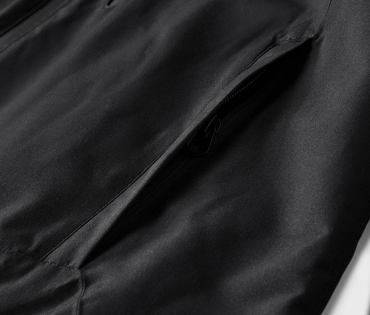 Detailaufnahme einer schwarzen Jacke mit Tasche.