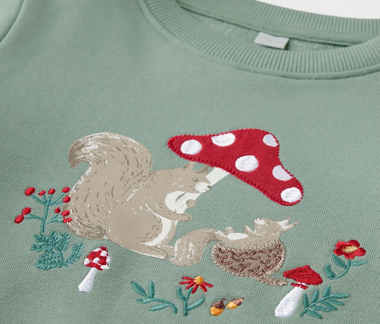 Grünes Kinder-Sweatshirt mit angerauter Innenseite und Stickerei aus Eichhörnchen, Pilz und Igel.