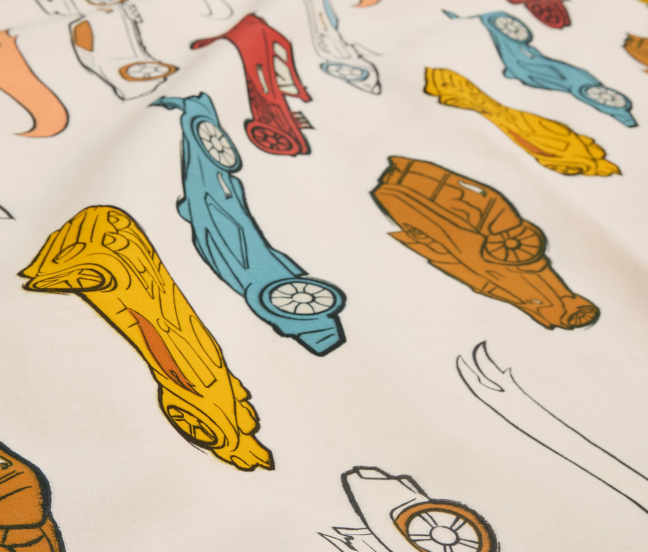 Detailansicht eines Stoffes, bedruckt mit stilisierten Rennwagen in verschiedenen Farben.