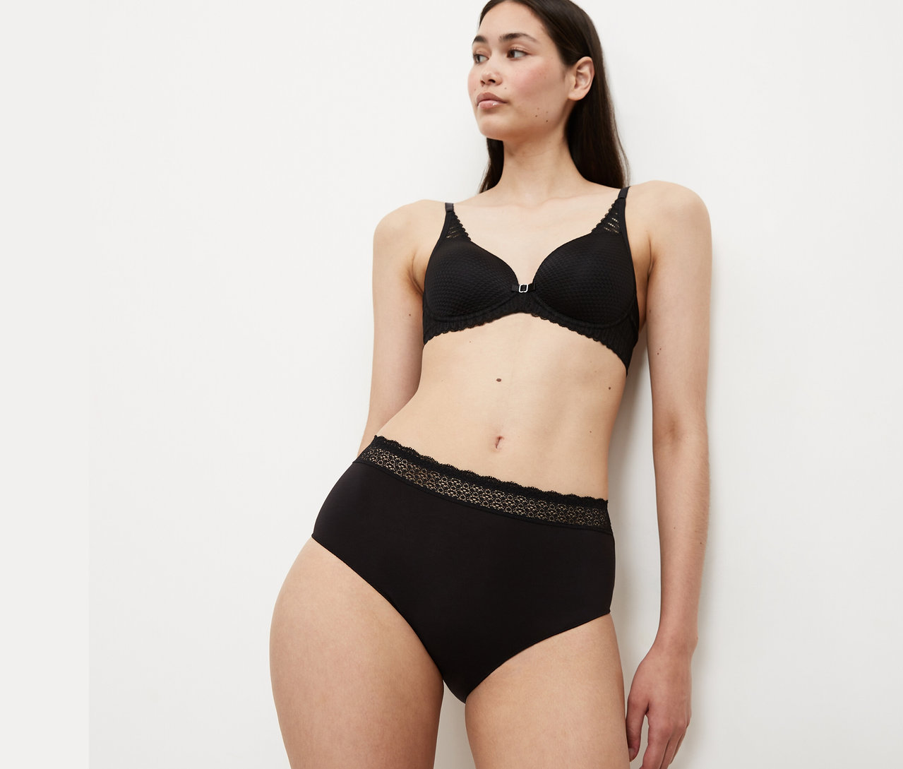 Frau trägt schwarzen BH und Slip.