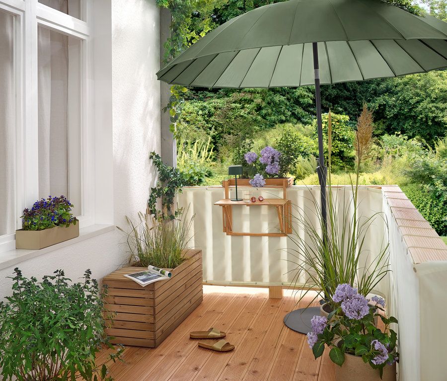 Auf einem Balkon steht ein grüner Leco Shanghai Sonnenschirm (Ø 270 cm) in einem flachen Leco Sonnenschirmständer (Ø ca. 60 cm).