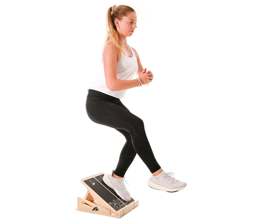 Frau macht Kniebeugen auf einem F2 Step on Balance Board.