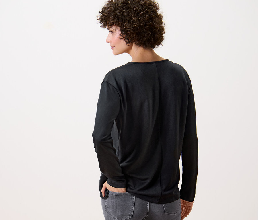 Frau von hinten trägt ein schwarzes Blusenshirt.