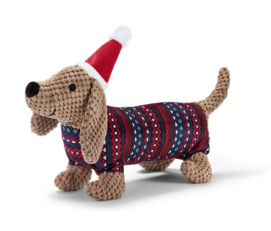 Ein Hunde-Plüschspielzeug »Dackel« trägt eine Weihnachtsmütze und einen Pullover.