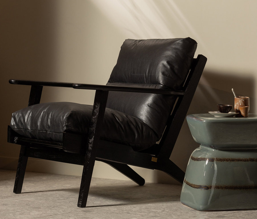 Schwarzer Sessel steht neben türkisfarbenem BePureHome Terra Beistelltisch, auf dem Tassen stehen.