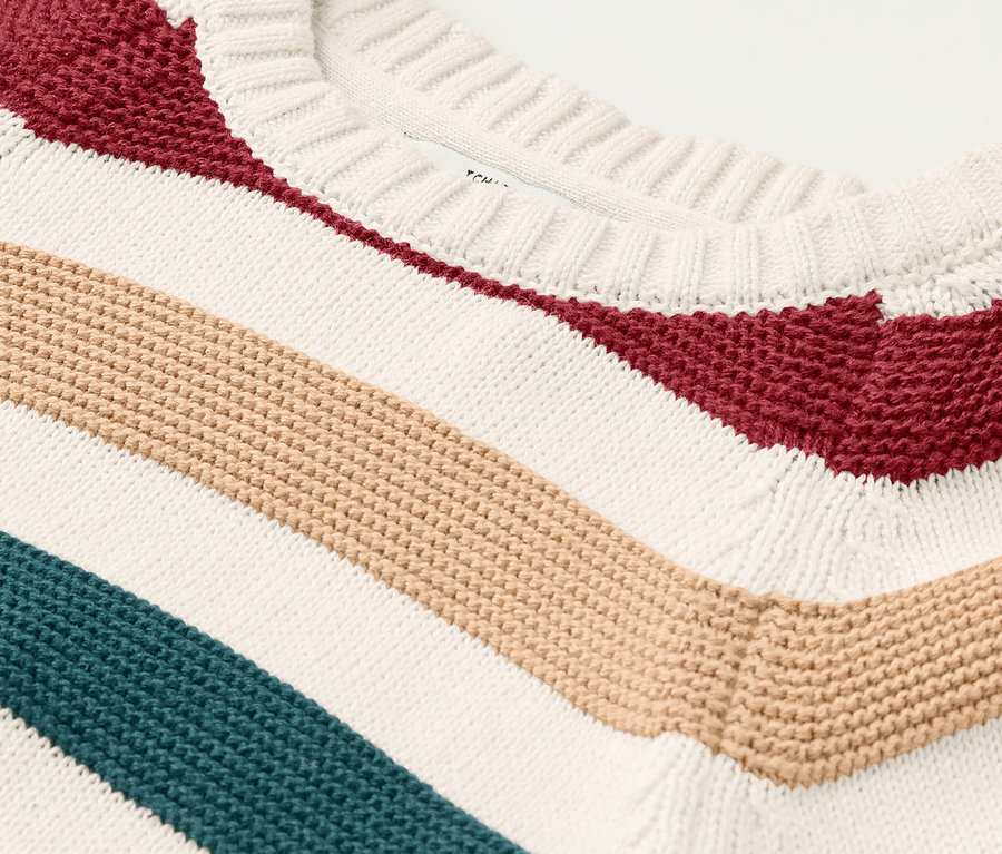 Detailansicht eines Kinder-Strickpullovers mit bunten Streifen.