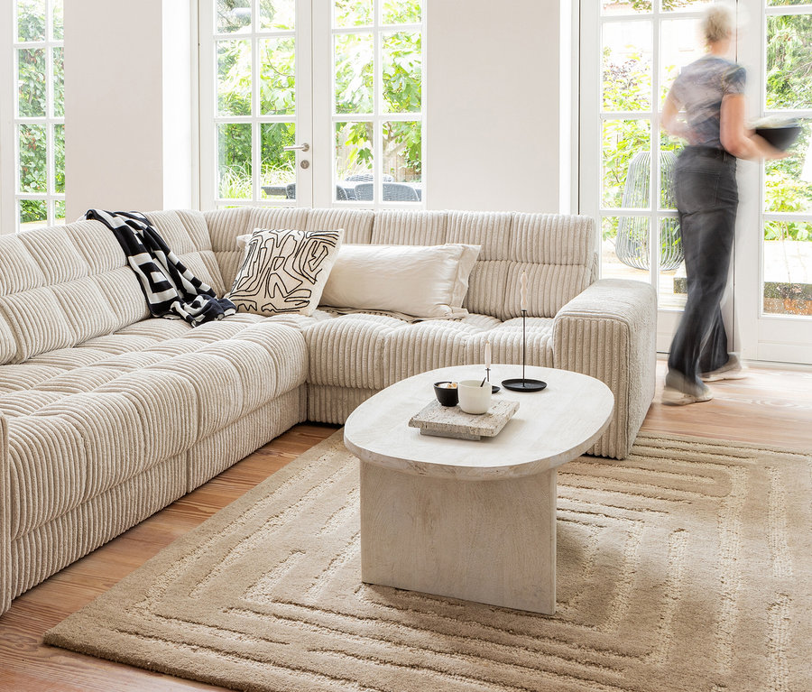 Wohnzimmer mit beigem Ecksofa, Couchtisch und sandfarbenem Woood Teppich Alicia.