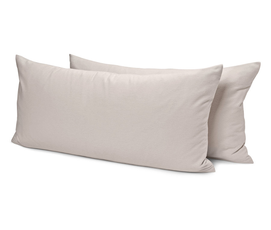 Zwei cremefarbene Kissen liegen übereinander.
