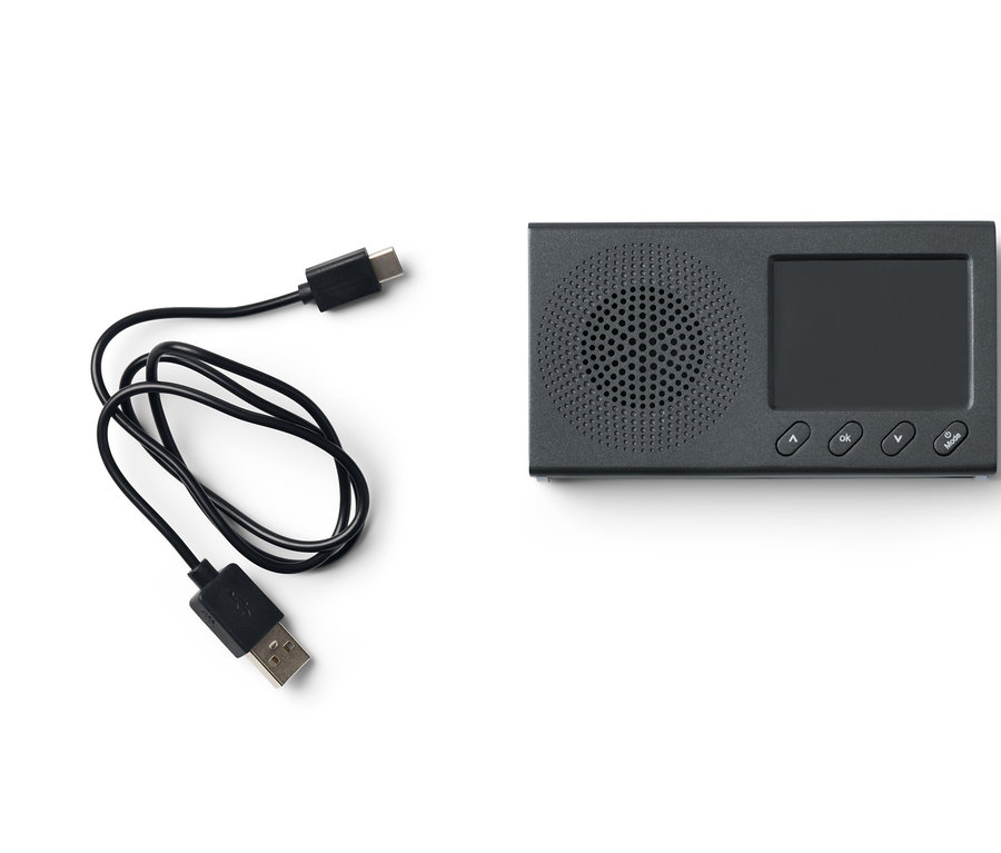 Ein schwarzes, tragbares DAB/FM-Radio mit Bluetooth und einem USB-Ladekabel liegt auf einem weißen Hintergrund.